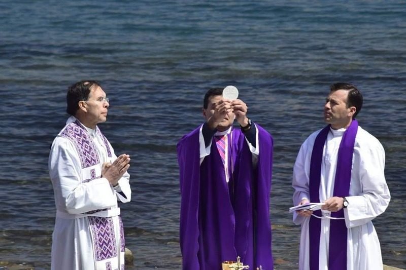 Sacerdotes celebrando la Eucaristía junto al mar